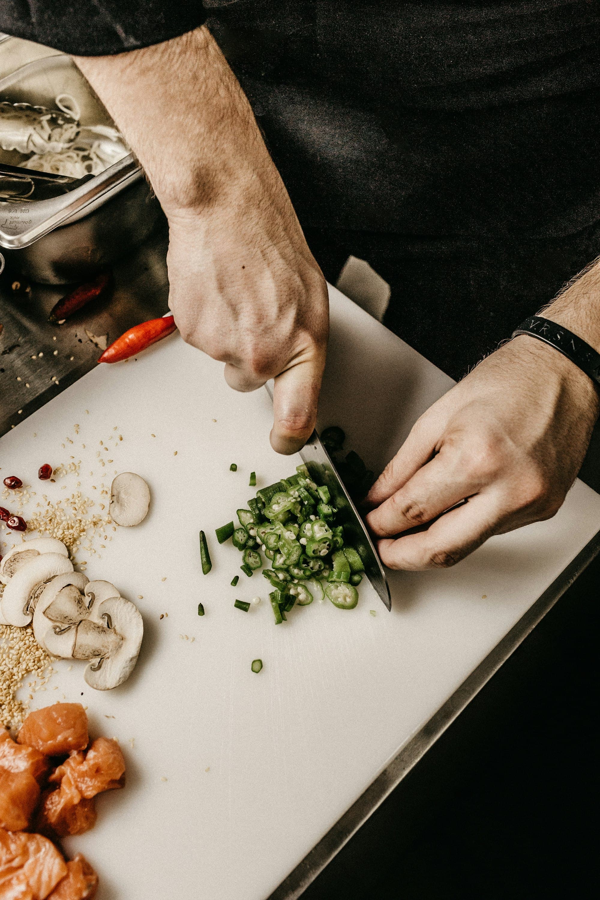 Chef chopping ingredients on stainless steel in a professional kitchen