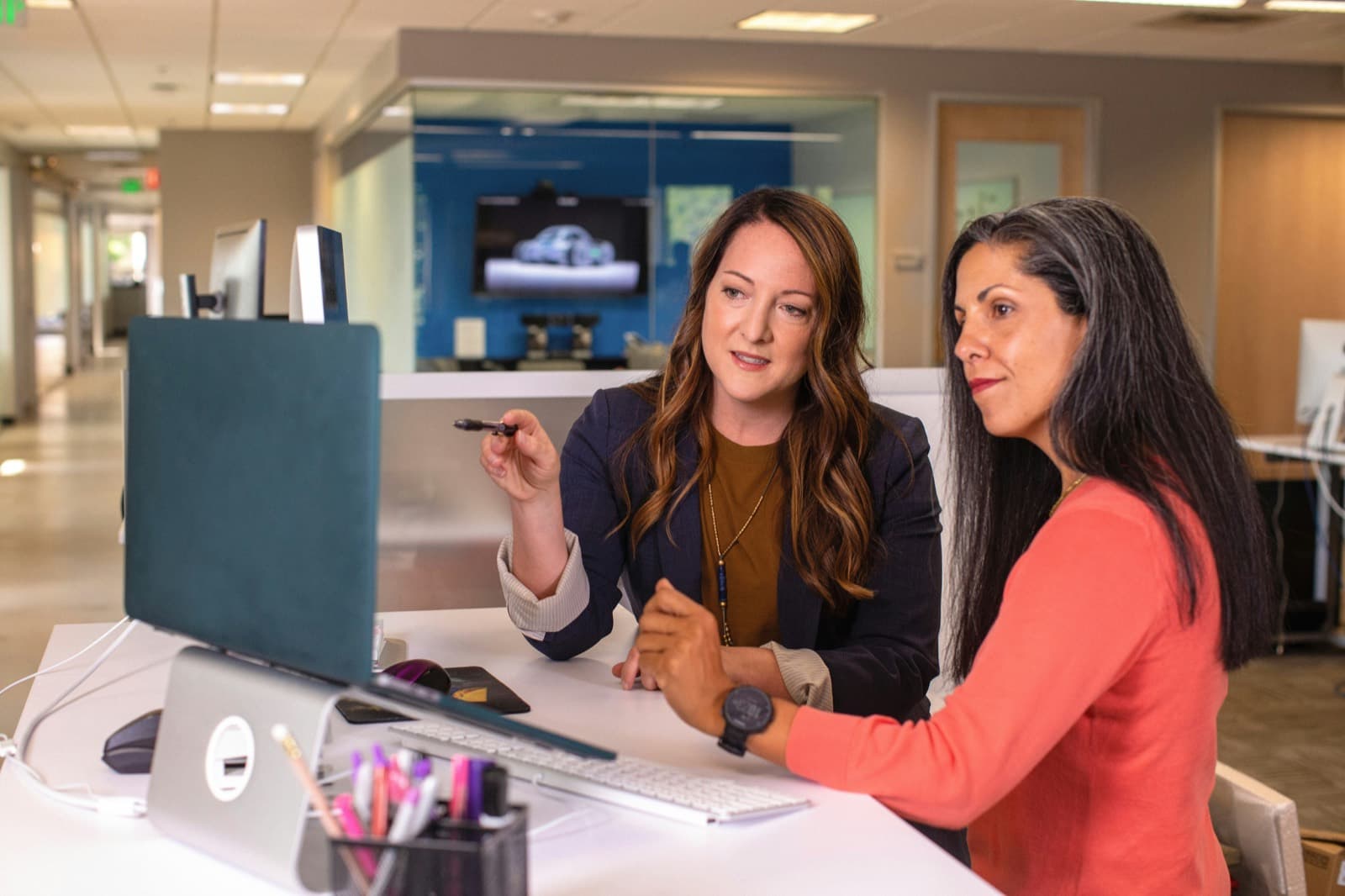 Two people reviewing work together at a studio desk