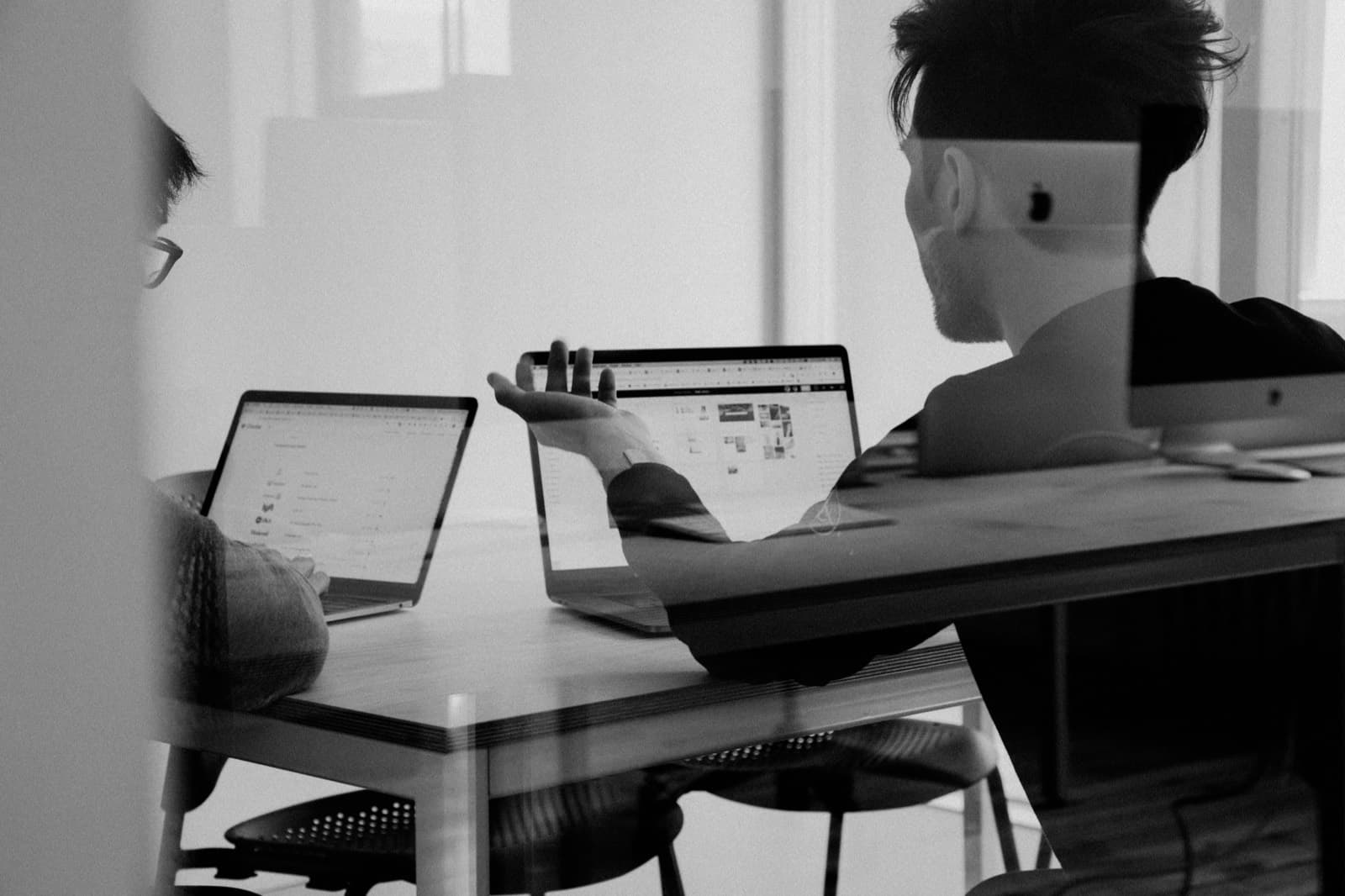 Two people working through a design on laptops